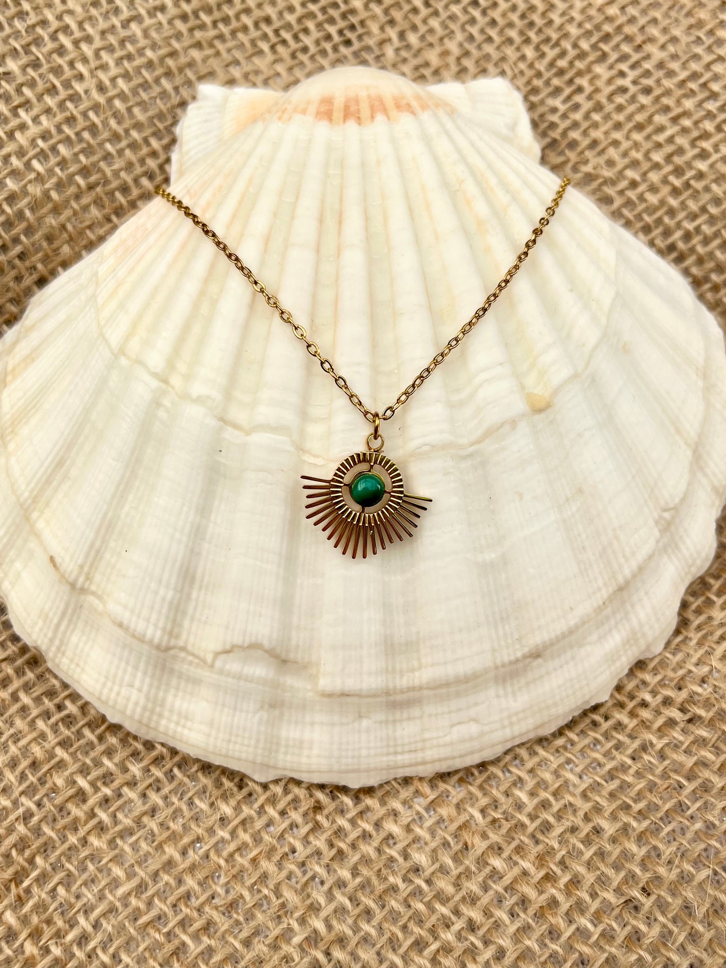 Collier ALLY, avec pierre de Malachite, exposé sur un coquillage.