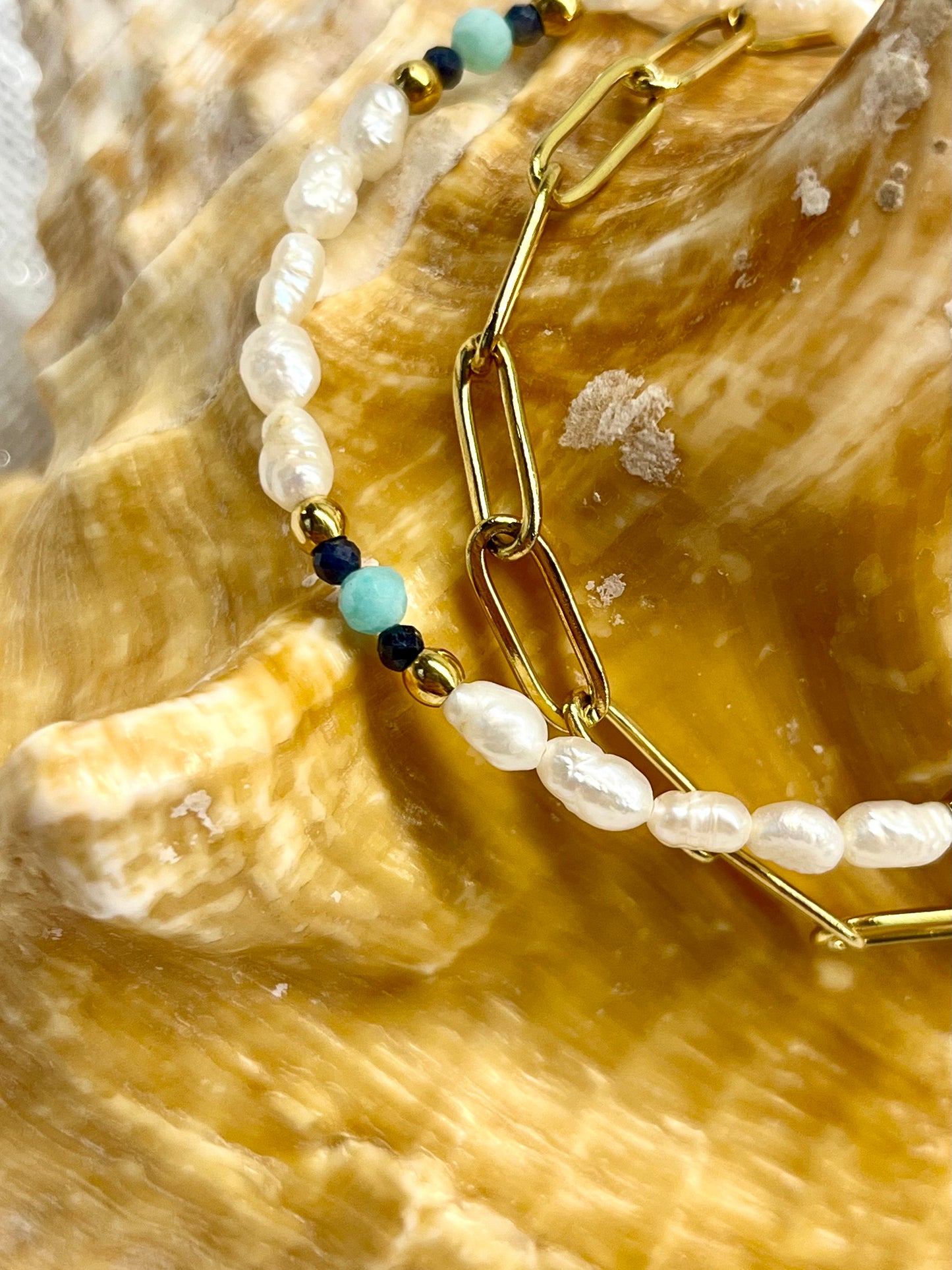 Bracelet ARIANA, avec pierre d'Amazonite, Saphir et Perle de Culture, exposé sur un coquillage.