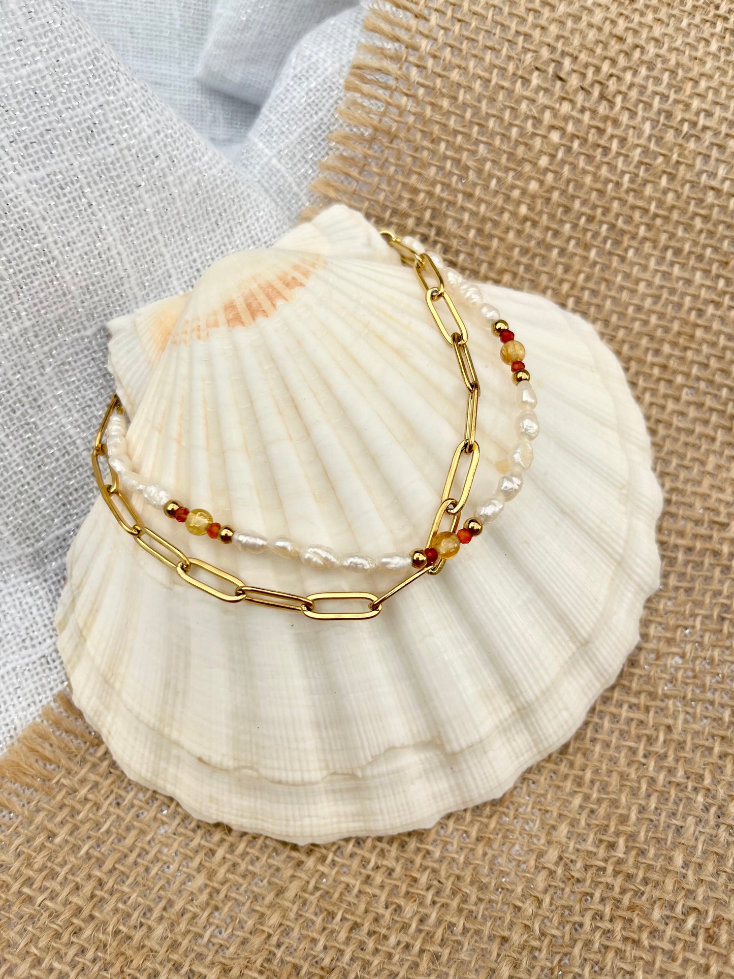 Bracelet ARIANA, avec pierres de Citrine, de Cornaline et Perles de Culture, exposé sur un coquillage.