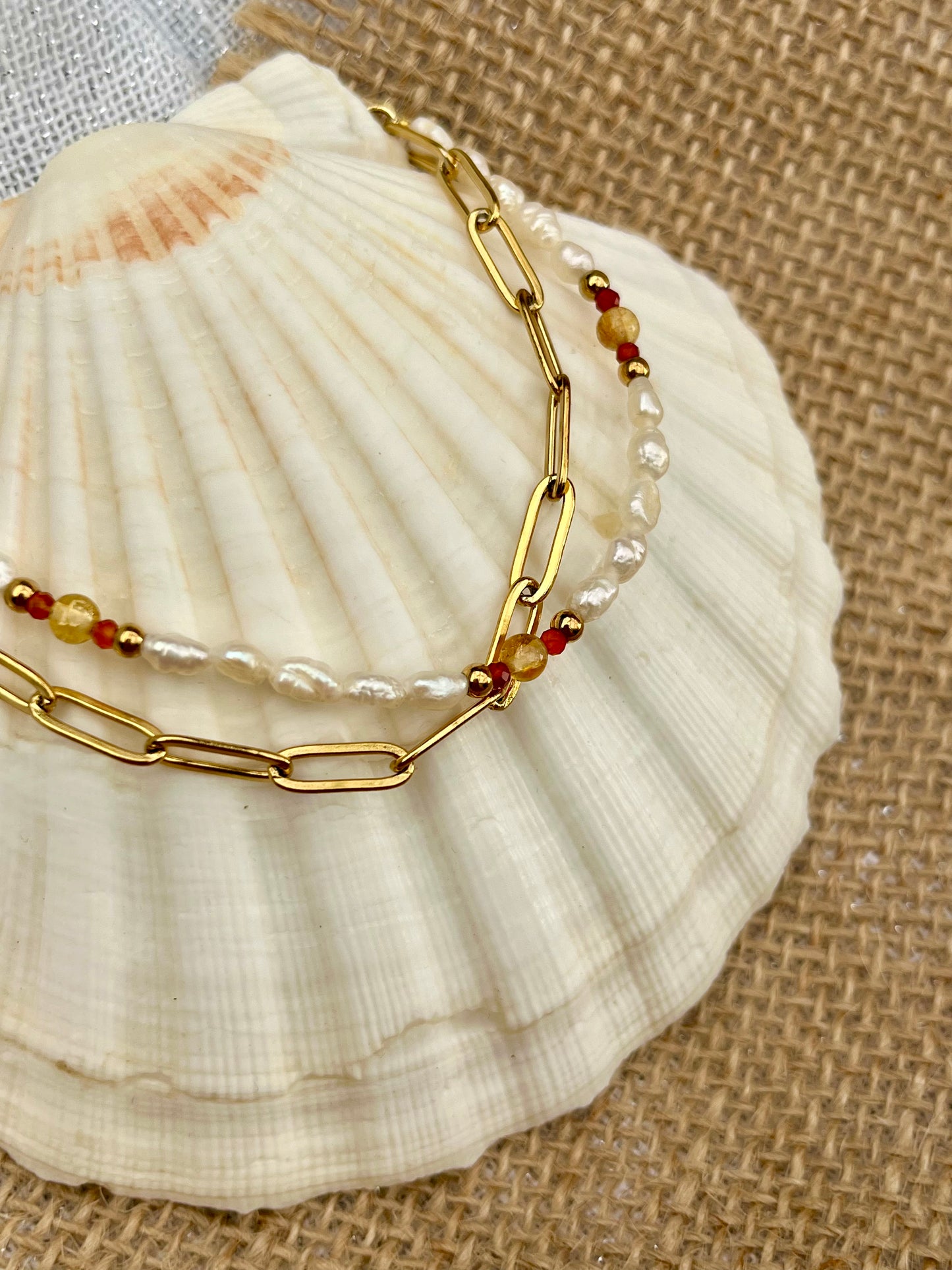Bracelet ARIANA, avec pierres de Citrine, de Cornaline et Perles de Culture, exposé sur un coquillage.