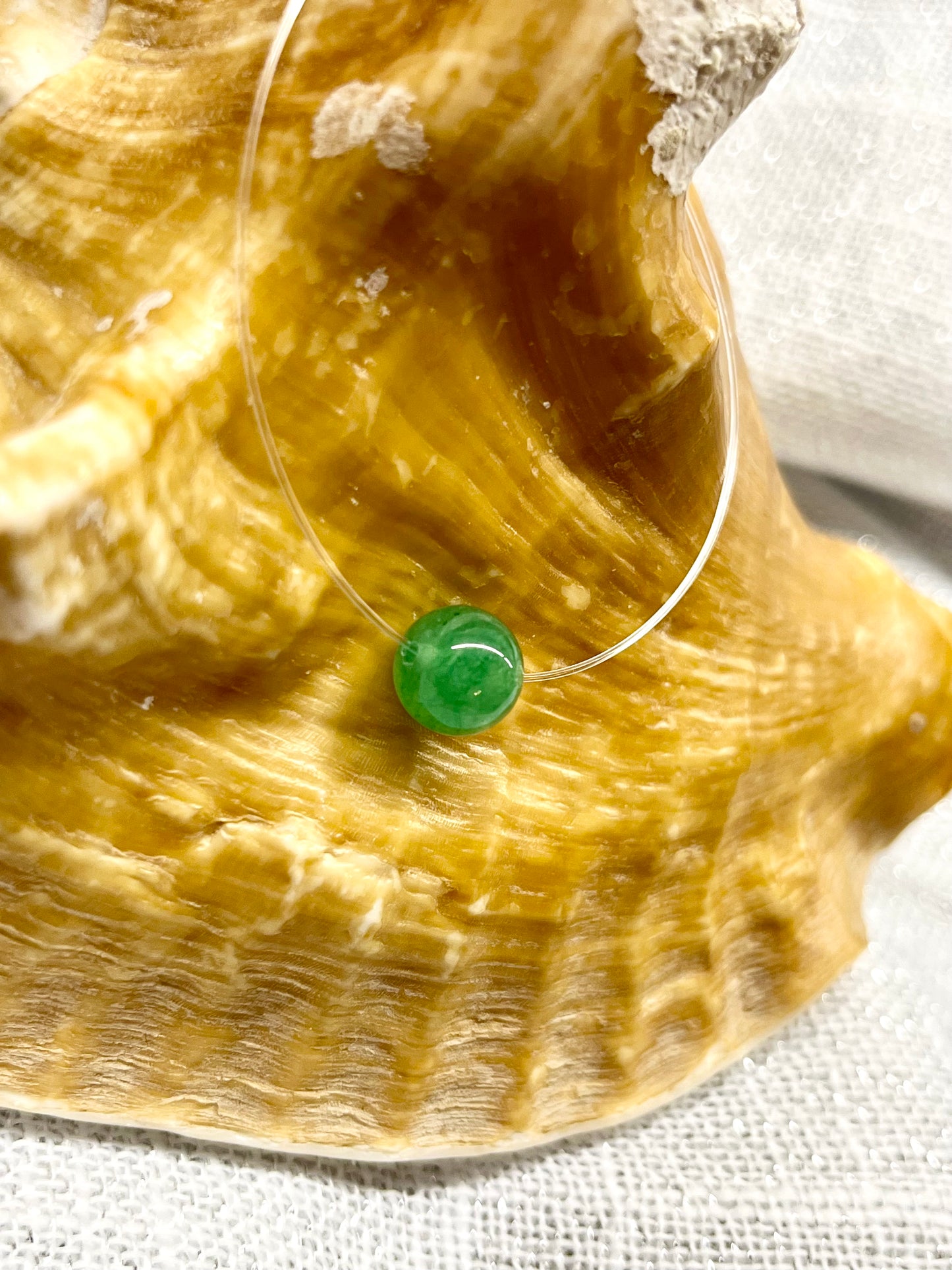 Collier EMY en pierre d'Aventurine, exposé sur un coquillage.