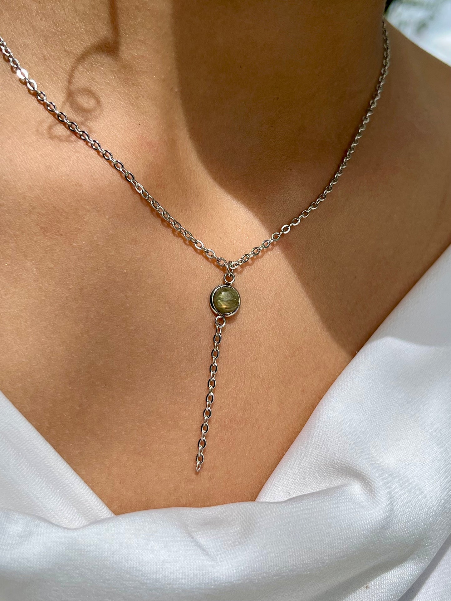 Collier LÉA, avec acier inoxydable argent et pierre de Labradorite, porté par une femme sur un haut blanc.