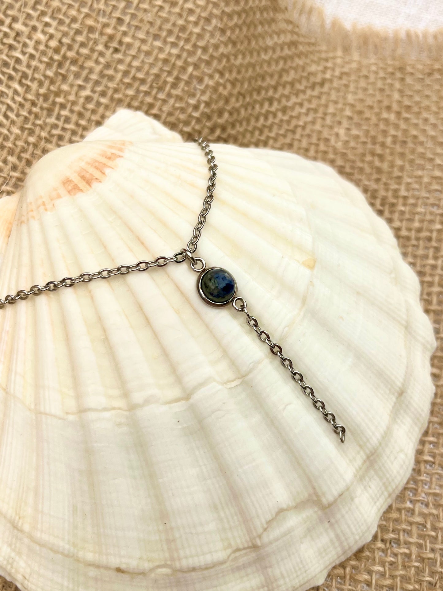 Collier LÉA, avec pierre de Sodalite, exposé sur un coquillage.