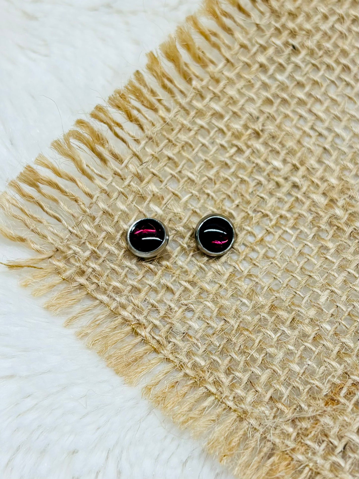 Boucles d'oreille LISE, avec pierre de Grenat, exposées sur un fond en toile de jute.