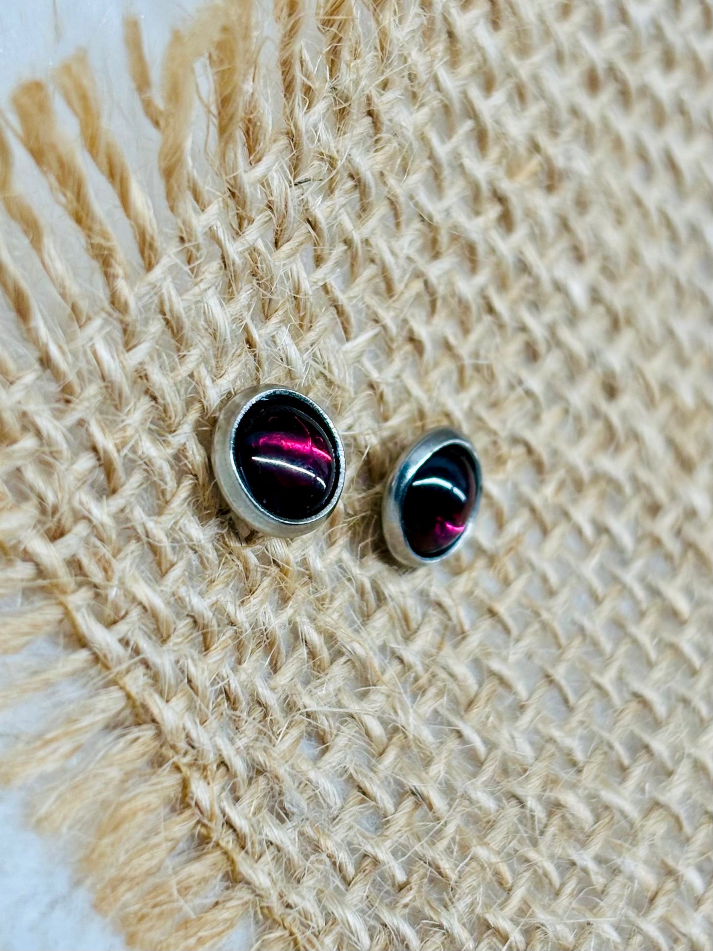 Boucles d'oreille LISE, avec pierre de Grenat, exposées sur un fond en toile de jute.