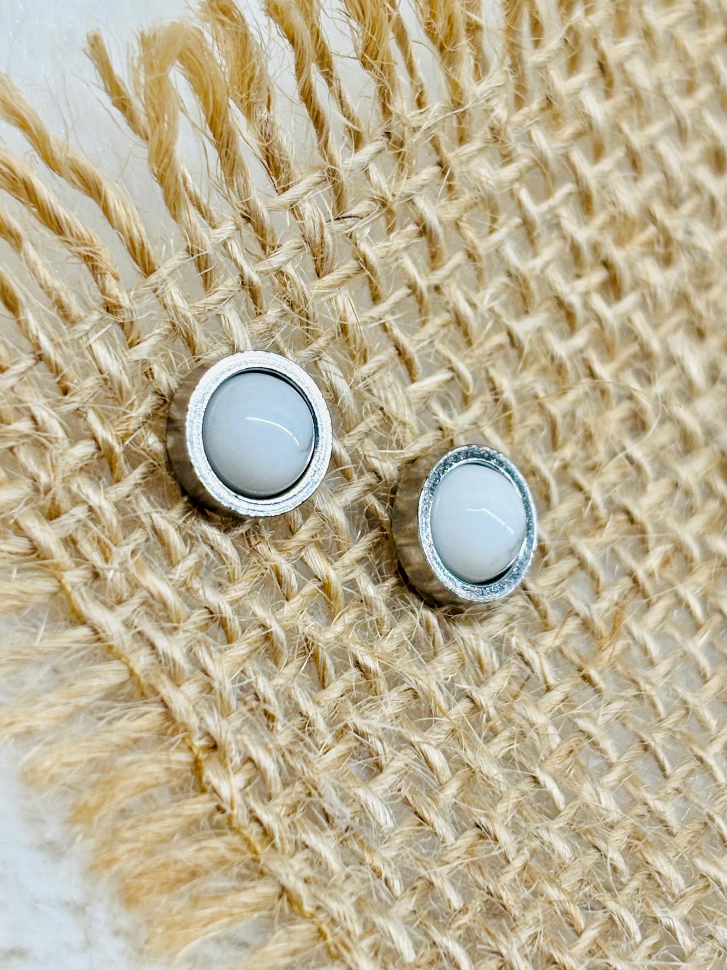Boucles d'oreille LISE, avec pierre d'Howlite, exposées sur un fond en toile de jute.
