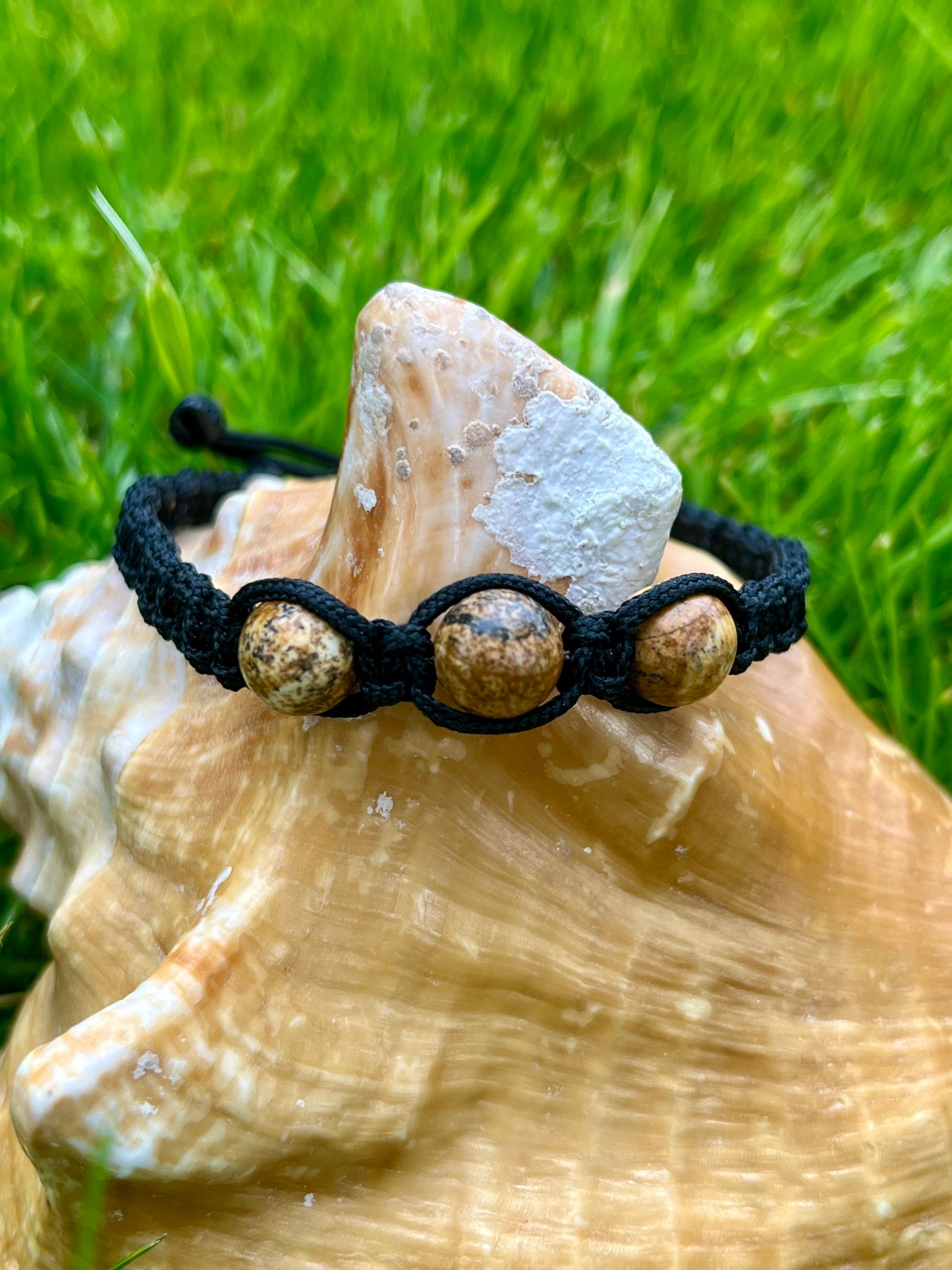 Bracelet MAËL, avec pierres de Jaspe Paysage, exposé sur un coquillage.