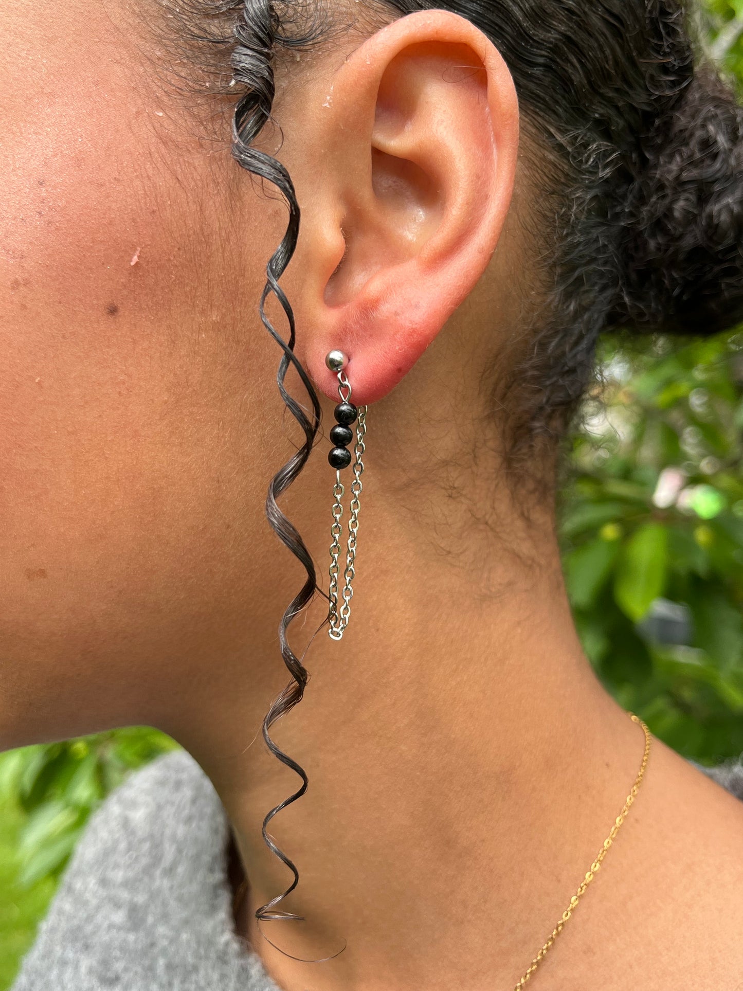 Boucles d'oreille MALIA, de couleur argent avec pierres de Tourmaline Noire, portées.