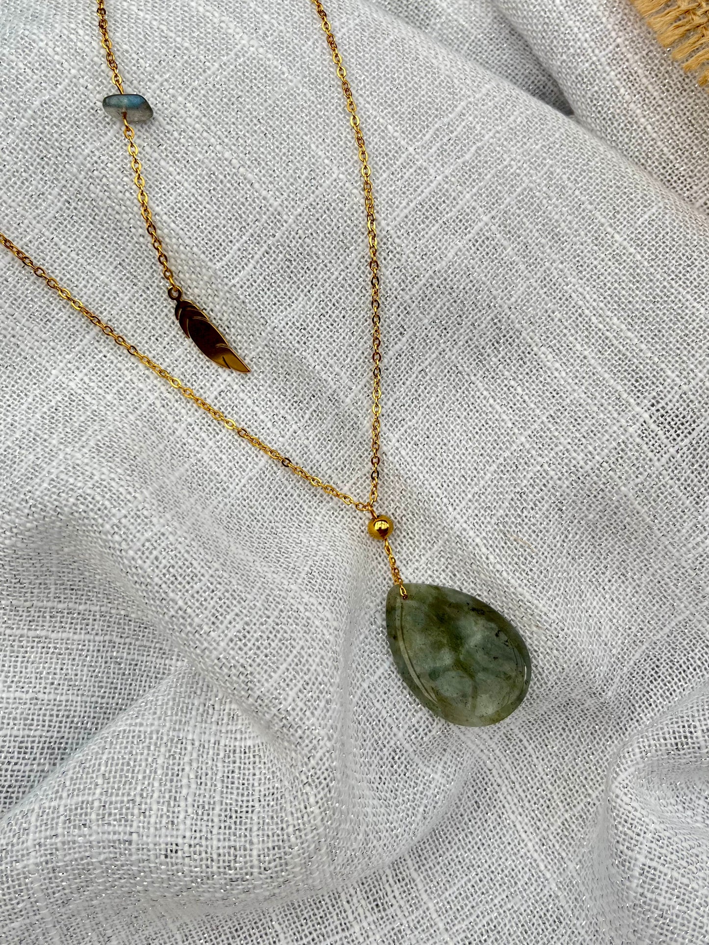 Collier NALIA, avec pierre de Labradorite, exposé sur un fond en lin.