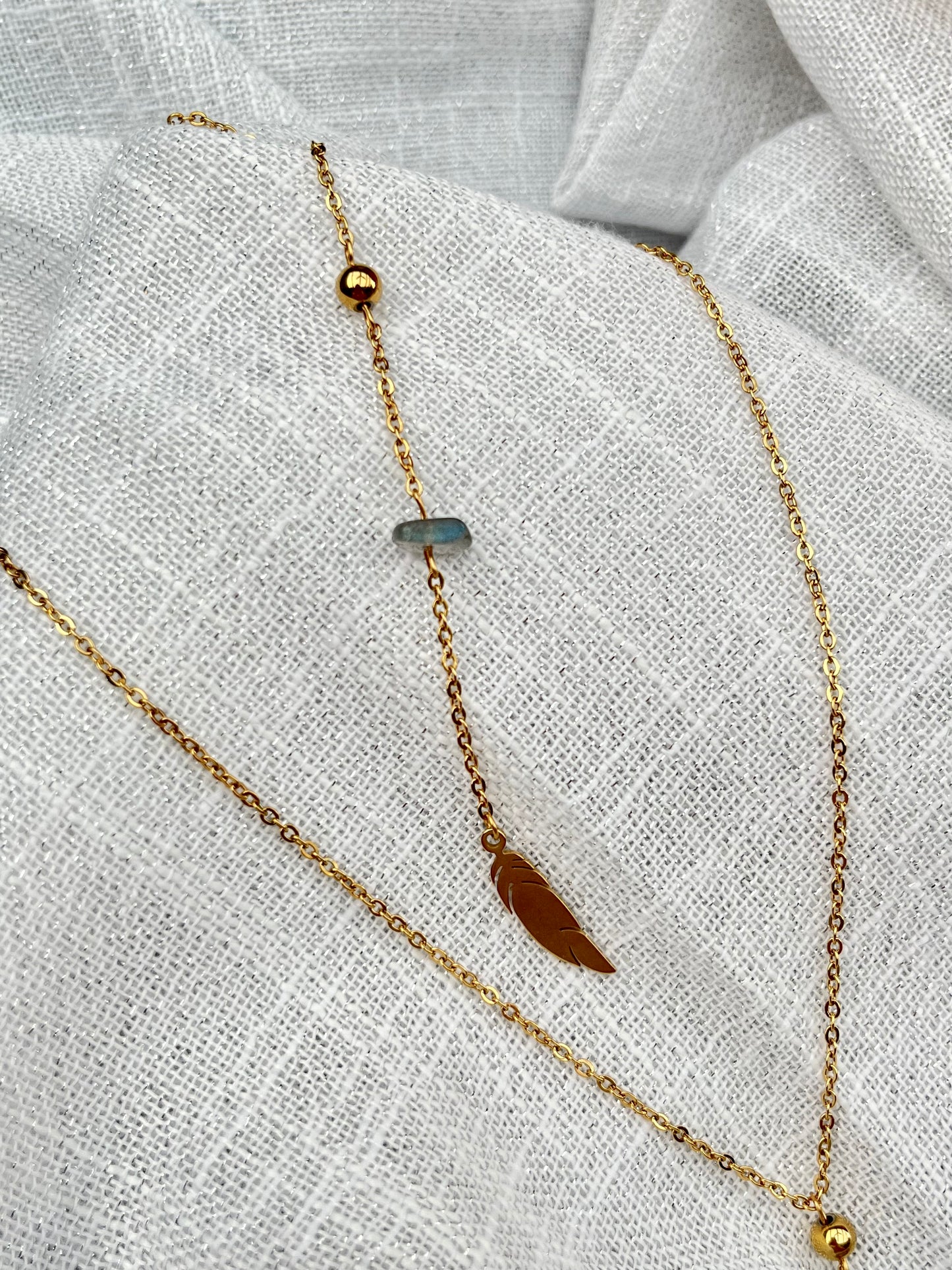 Collier NALIA, avec pierre de Labradorite, exposé sur un fond en lin.