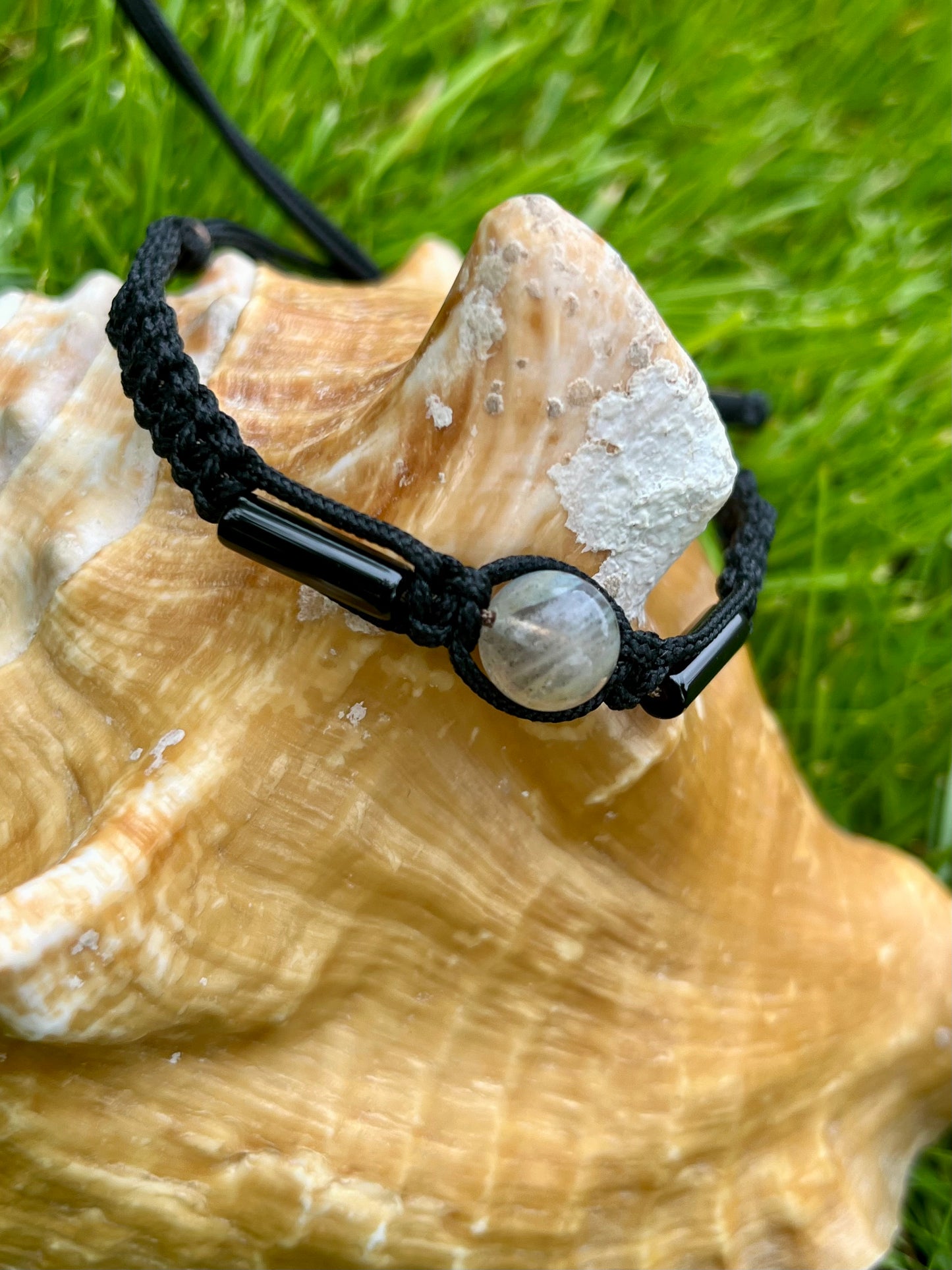 Bracelet NOAH, avec pierre de Labradorite et d'Agate, exposé sur un coquillage.