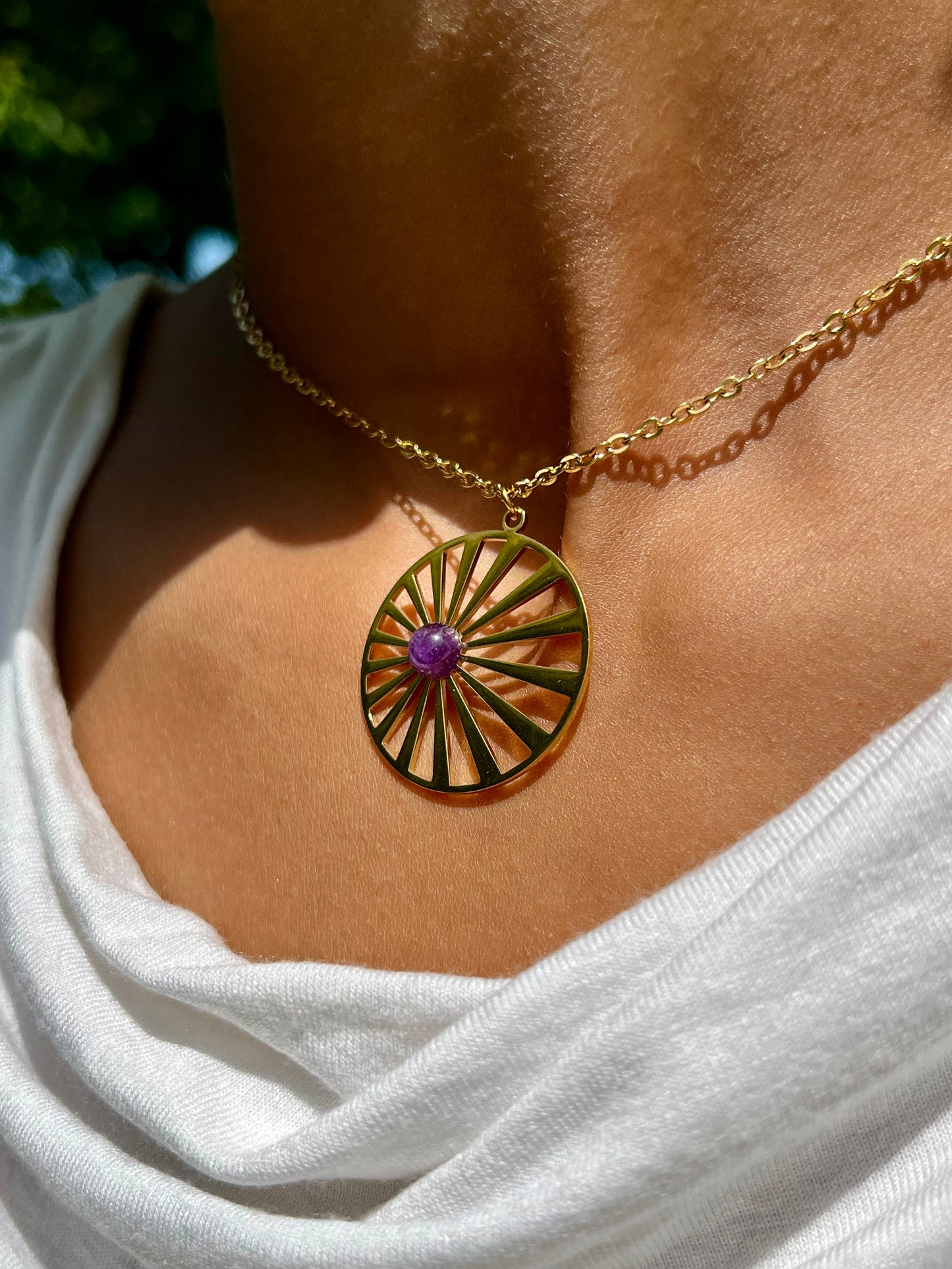 Collier SANA, avec pierre d'Améthyste, porté sur un haut blanc.