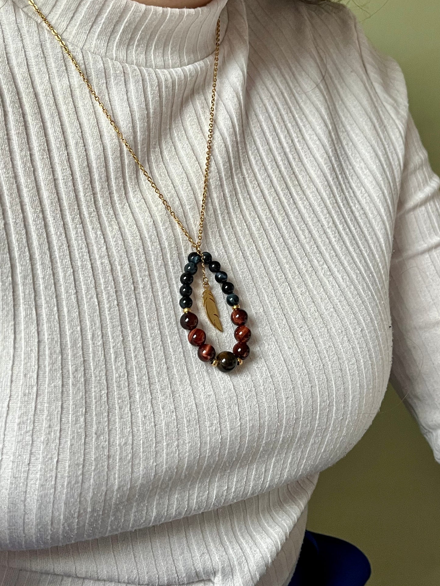 Collier SIMONE, avec pierre d'Oeil de Tigre, de Taureau et de Faucon, porté par une femme sur un haut blanc.
