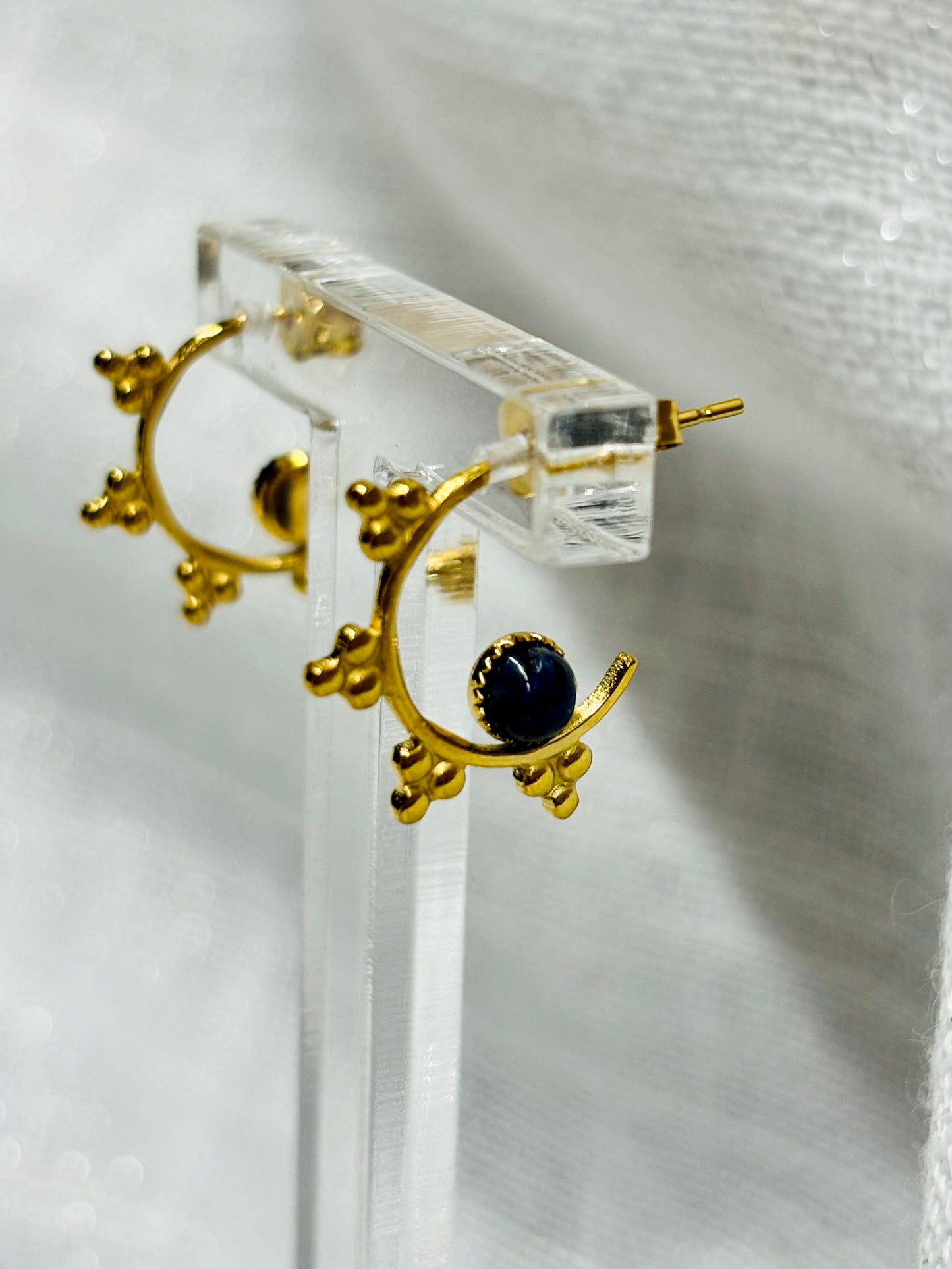 Boucles d'Oreille VICTORIA, avec pierre de Lapis-Lazuli, exposé devant un fond en lin.