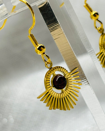 Boucles d'oreille ALLY, avec pierre de Grenat, exposées sur un fond en lin.