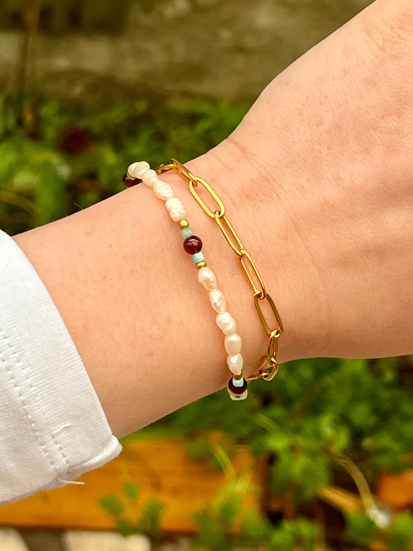Bracelet ARIANA, avec pierre d'Amazonite, de Grenat et Perle de Culture, porté sur un poignet de femme.