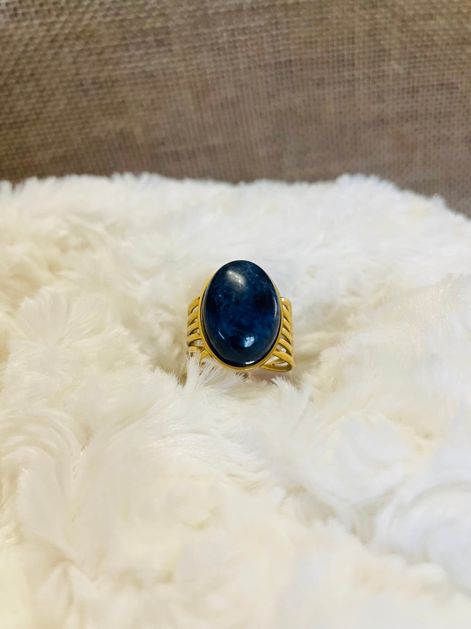 Bague DIANA, avec pierre de Sodalite, exposée sur un fond en fourrure.