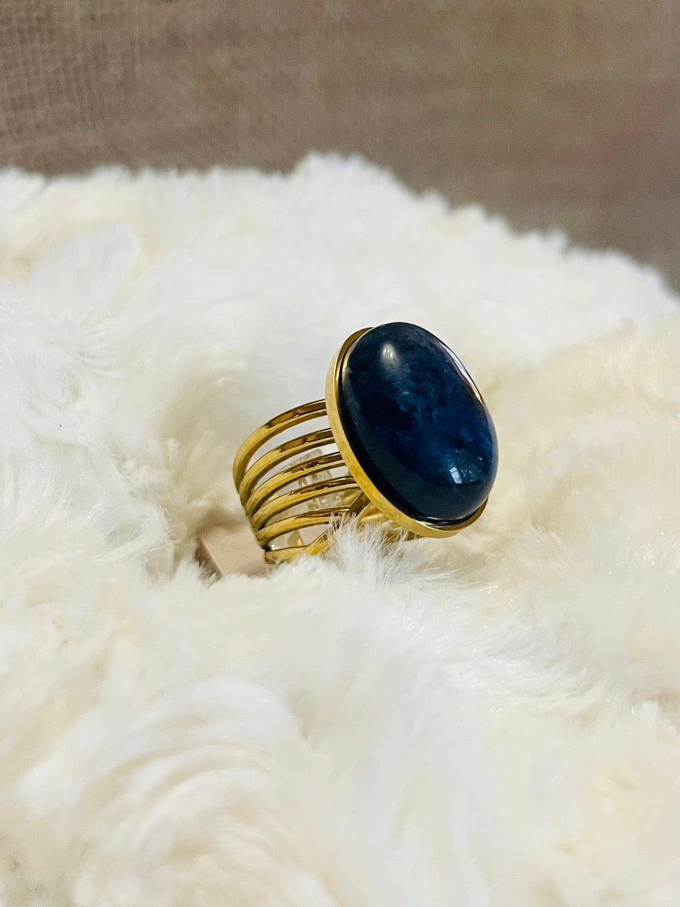 Bague DIANA, avec pierre de Sodalite, exposée sur un fond en fourrure.