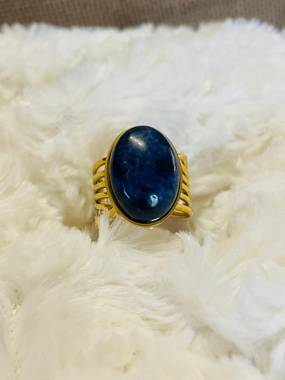 Bague DIANA, avec pierre de Sodalite, exposée sur un fond en fourrure.
