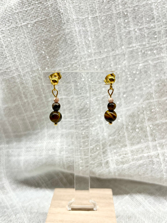 Boucles d'oreille EMMA, aevc pierre d'Oeil de Tigre et de Rhodochrosite, exposées sur un fond en lin.