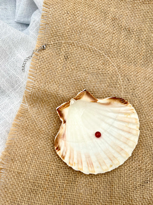 Collier EMY, avec pierre de Cornaline, exposé dans un coquillage.