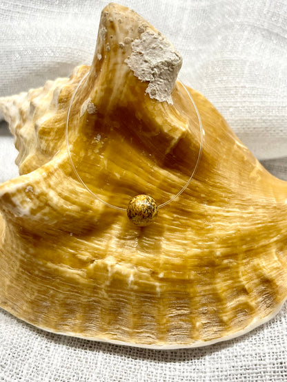 Collier EMY en Jaspe Paysage, exposé sur un coquillage.