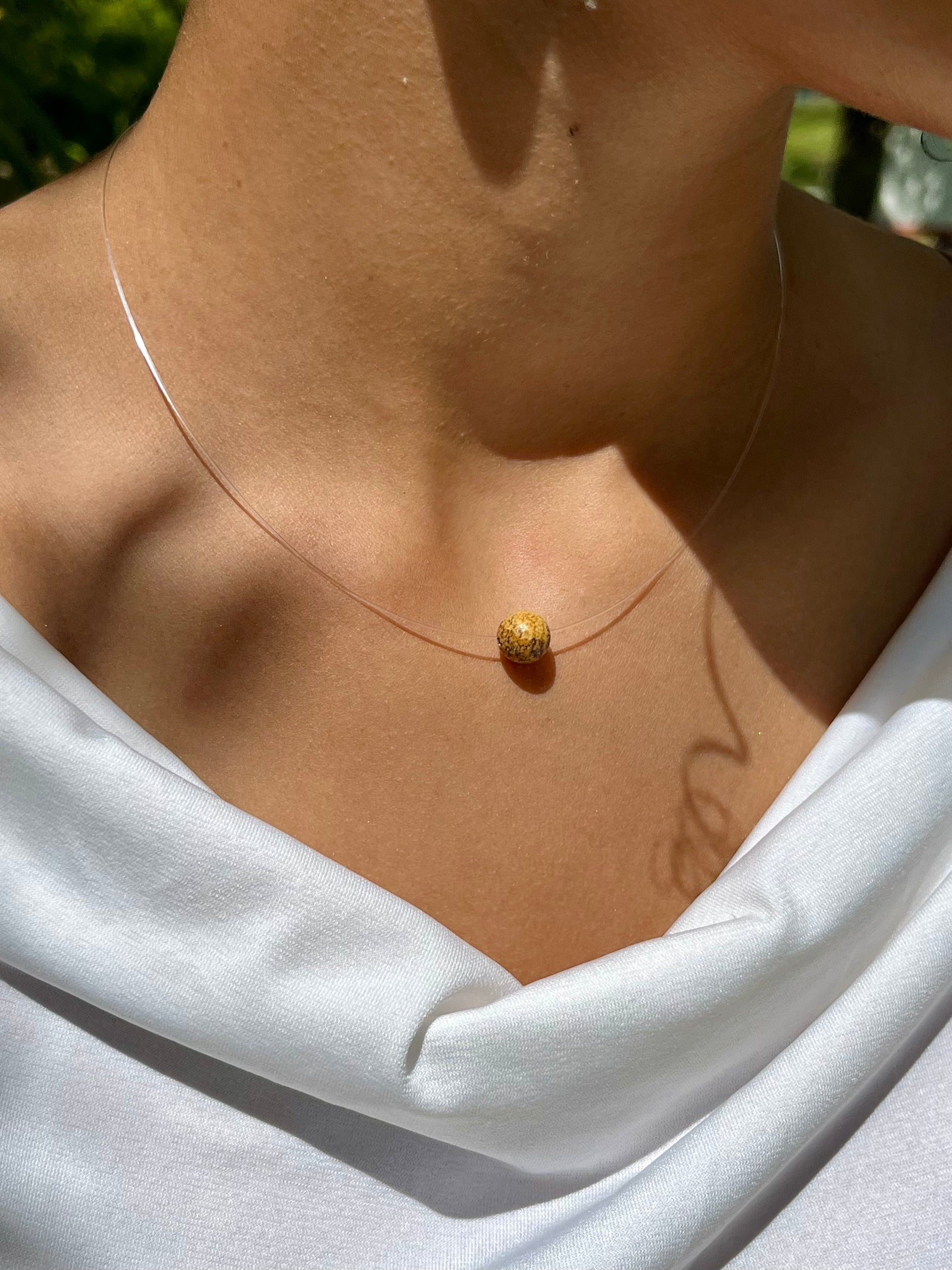 Collier EMY en Jaspe Paysage, porté sur un haut blanc.