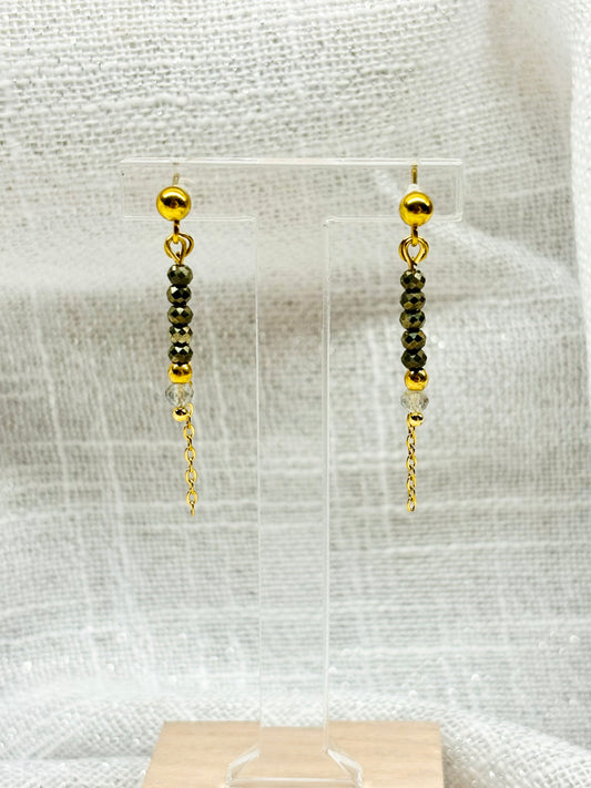 Boucles d'oreille JULIETTE, avec pierres de Pyrite et de Labradorite, exposées sur un fond en lin.