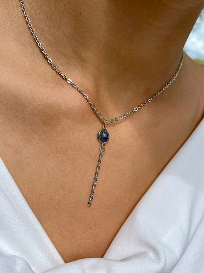 Collier LÉA, en acier inoxydable argent et pierre de Sodalite, porté sur un haut blanc.