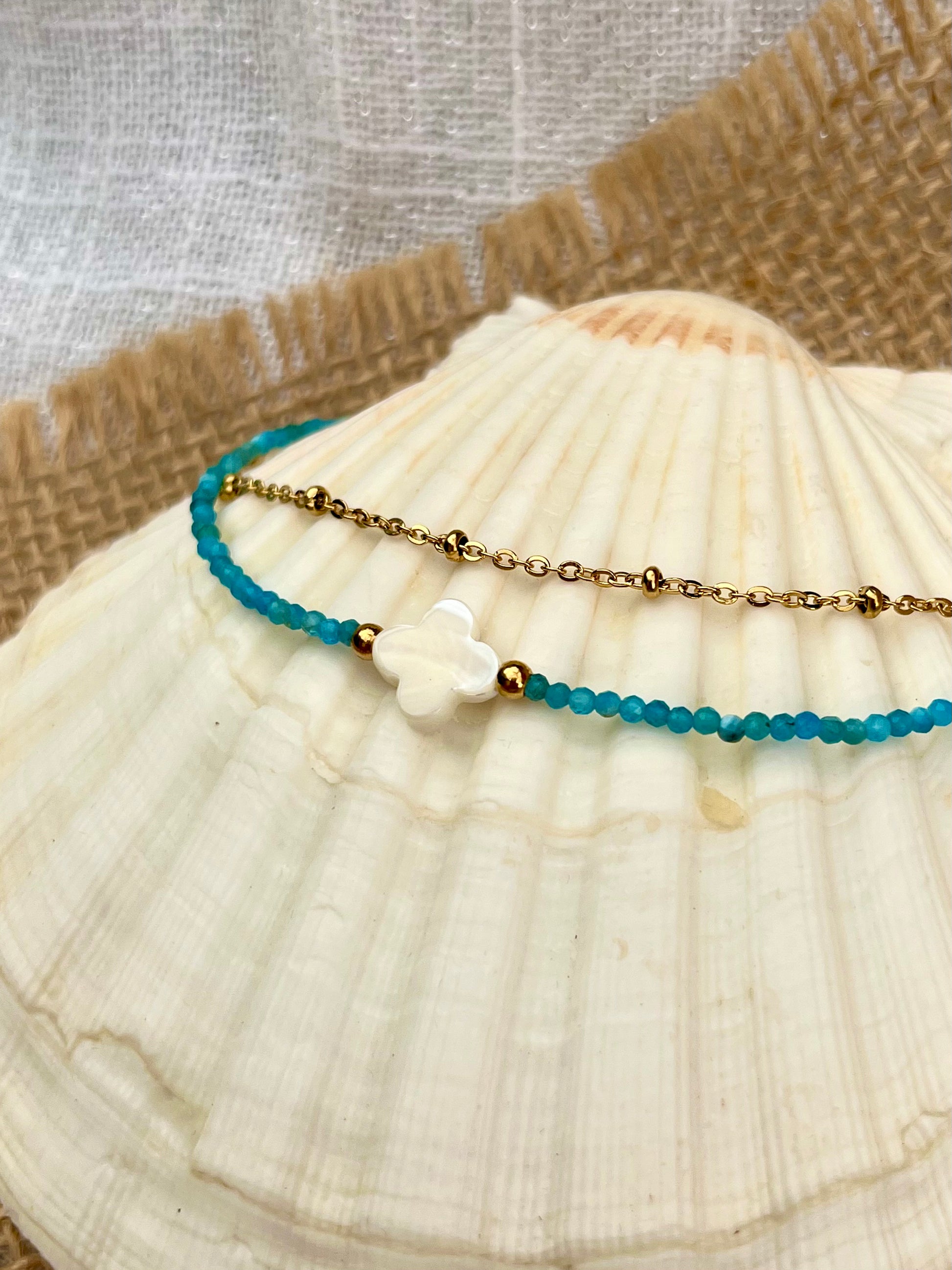 Bracelet LINA, avec pierre d'Apatite et Nacre, exposé sur un coquillage.