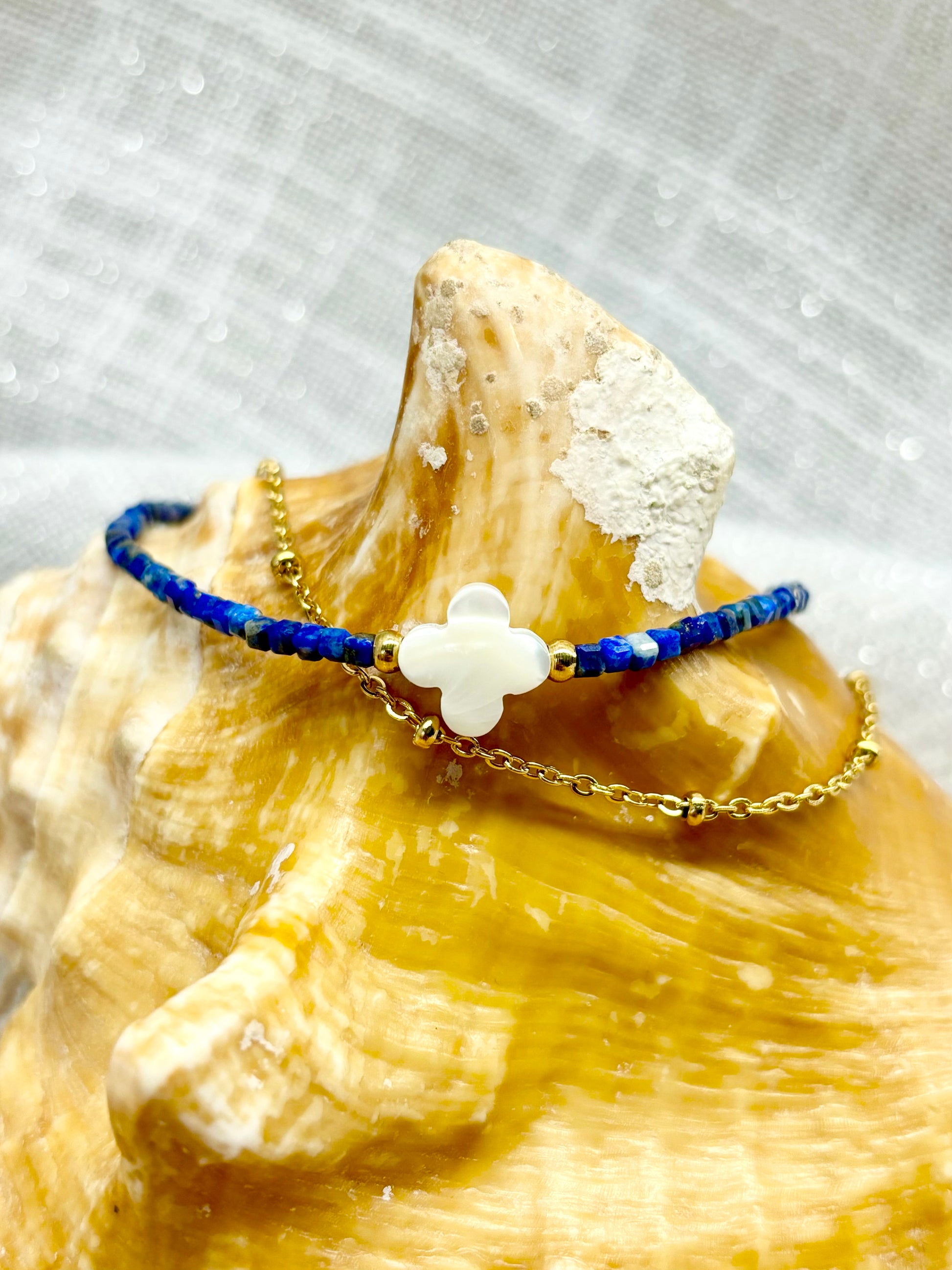 Bracelet LINA, avec pierres de Lapis-Lazuli et de Nacre, exposé sur un coquillage.
