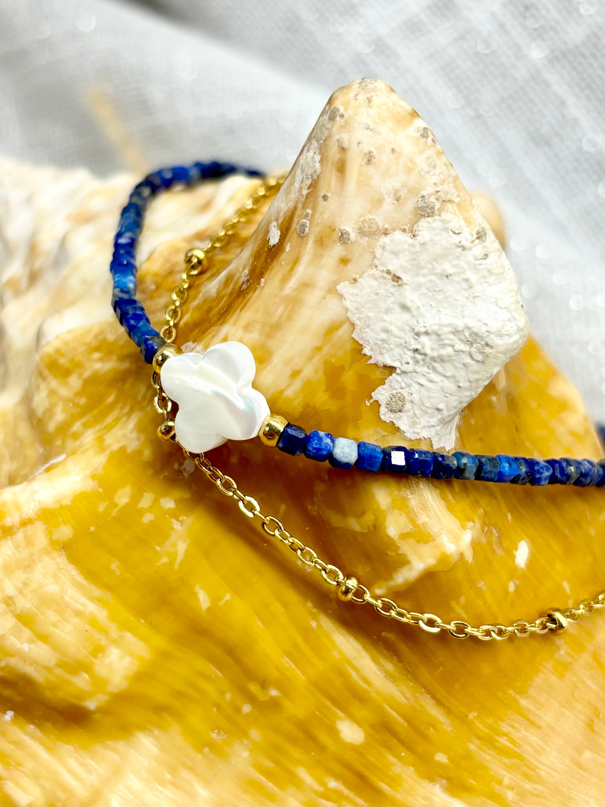 Bracelet LINA, avec pierres de Lapis-Lazuli et de Nacre, exposé sur un coquillage.