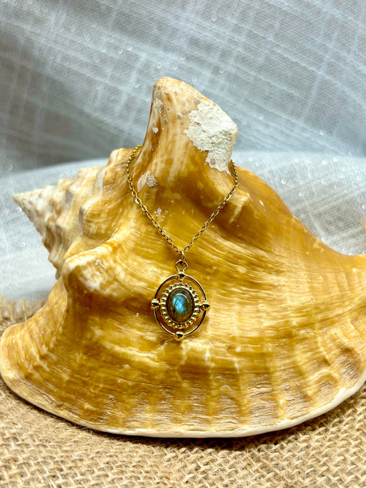 Collier LOUISA, avec pierre de Labradorite, exposé sur un coquillage.