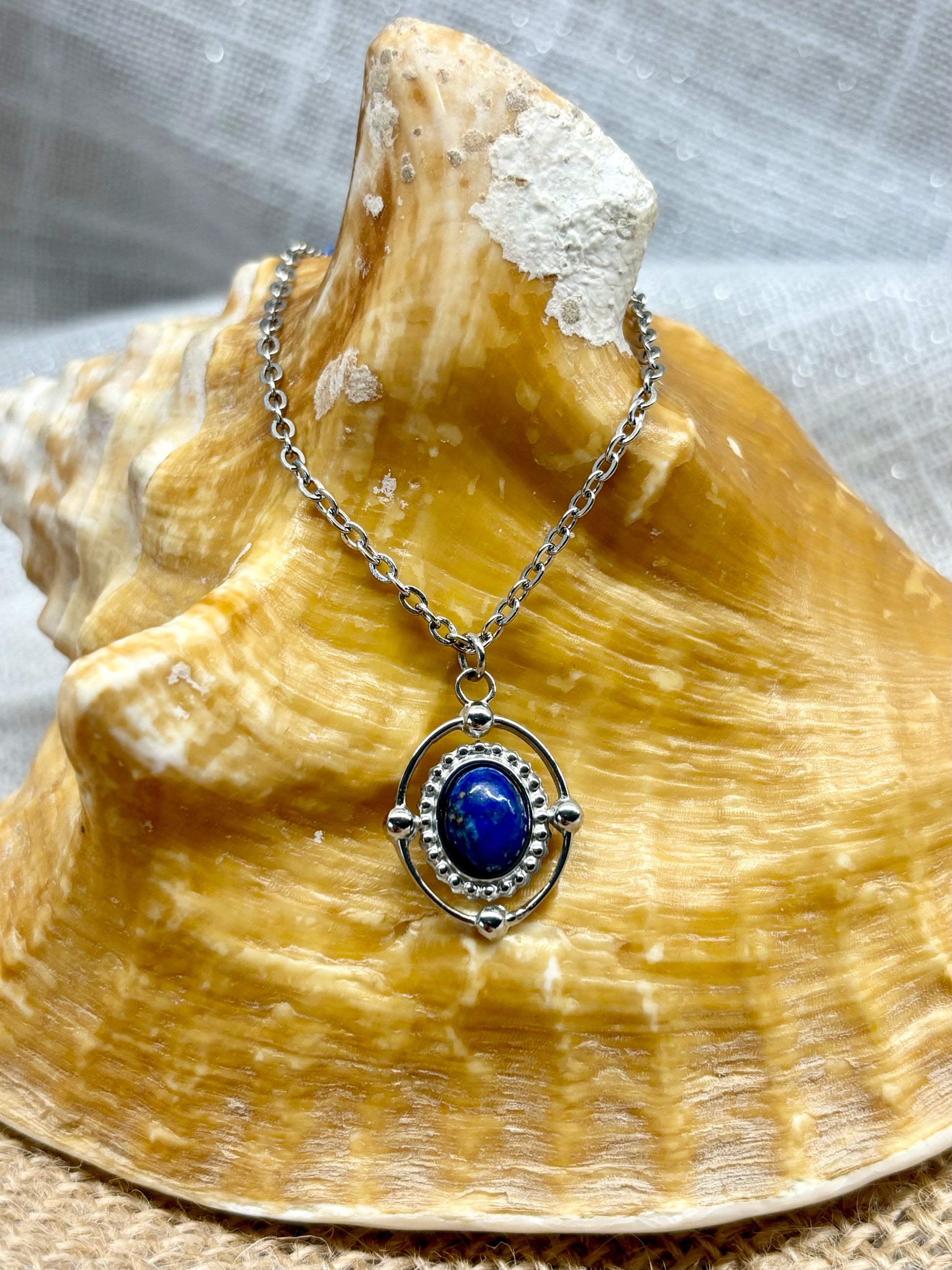 Collier LOUISA, avec pierre de Lapis-Lazuli, exposé sur un coquillage.