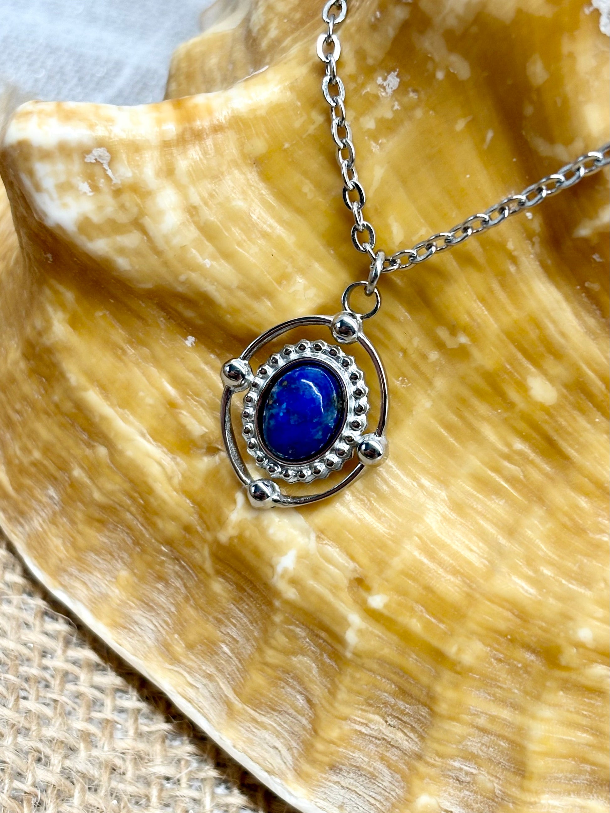 Collier LOUISA, avec pierre de Lapis-Lazuli, exposé sur un coquillage.