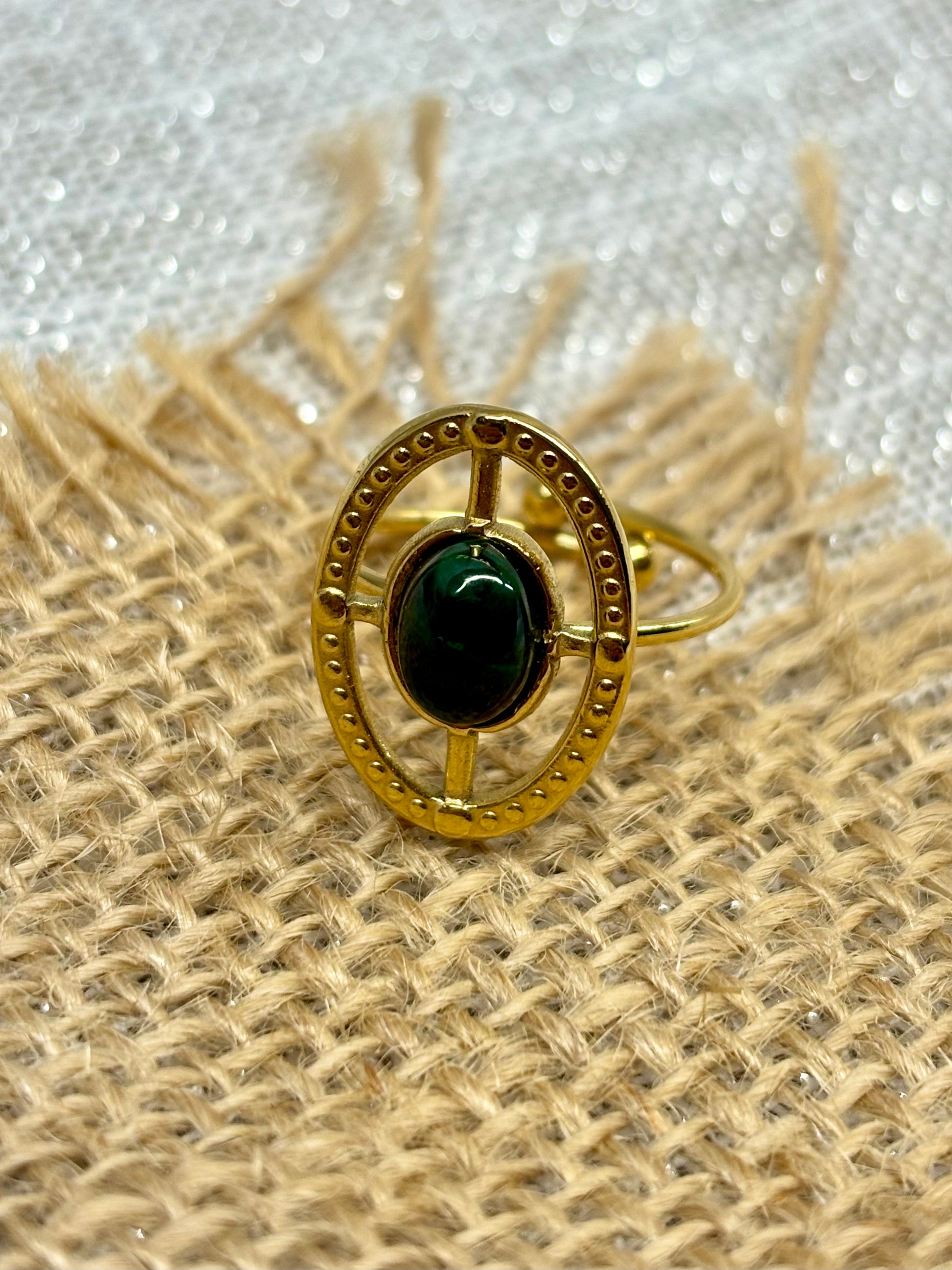Bague LOUISE, avec pierre de Malachite, exposée sur un fond en toile de jute.