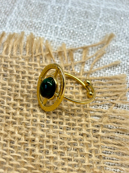Bague LOUISE, avec pierre de Malachite, exposée sur un fond en toile de jute.