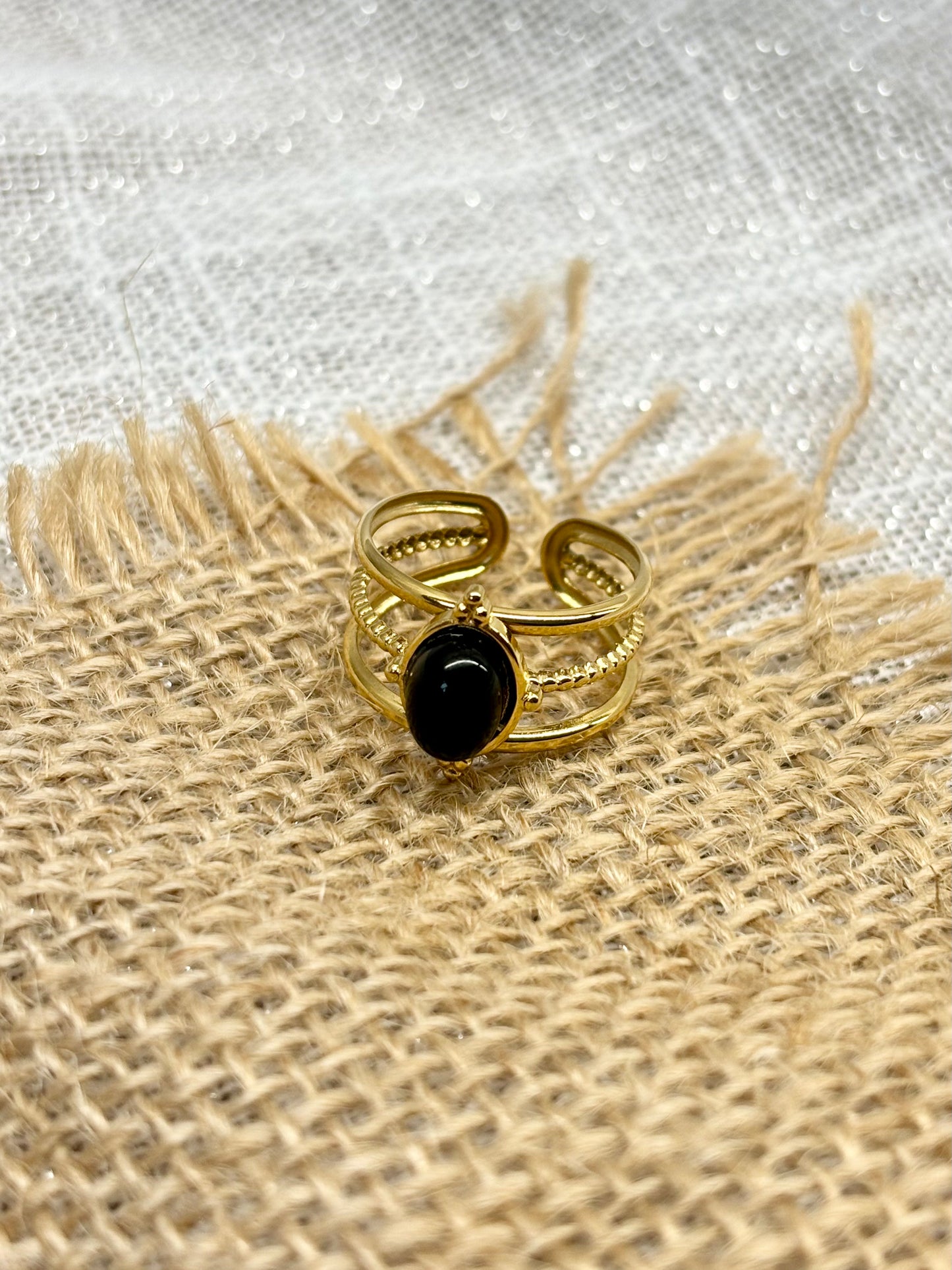 Bague LOUISON, avec pierre d'Agate, exposée sur un fond de toile de jute.