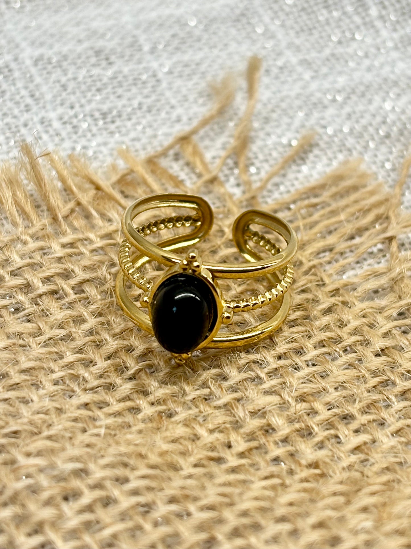Bague LOUISON, avec pierre d'Agate, exposée sur un fond de toile de jute.