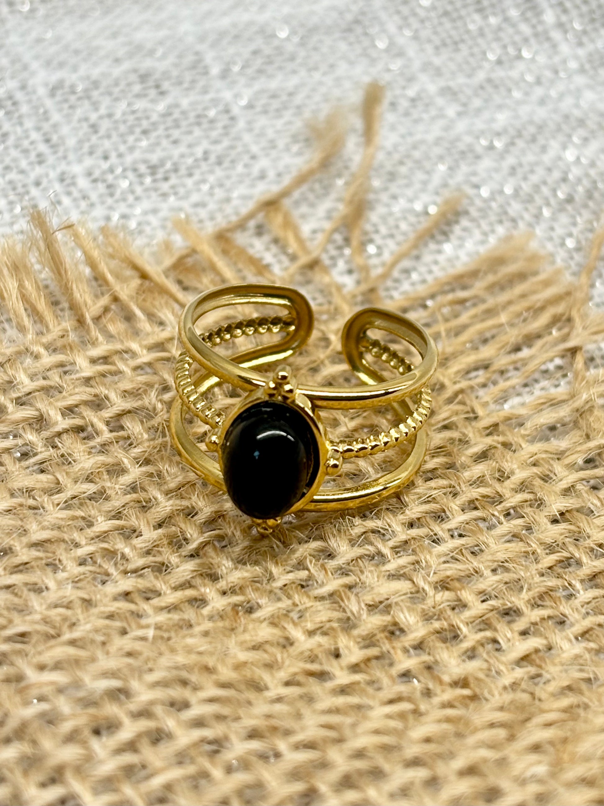 Bague LOUISON, avec pierre d'Agate, exposée sur un fond de toile de jute.