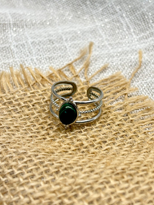 Bague LOUISON, avec pierre de Malachite, exposée sur de la toile de jute.