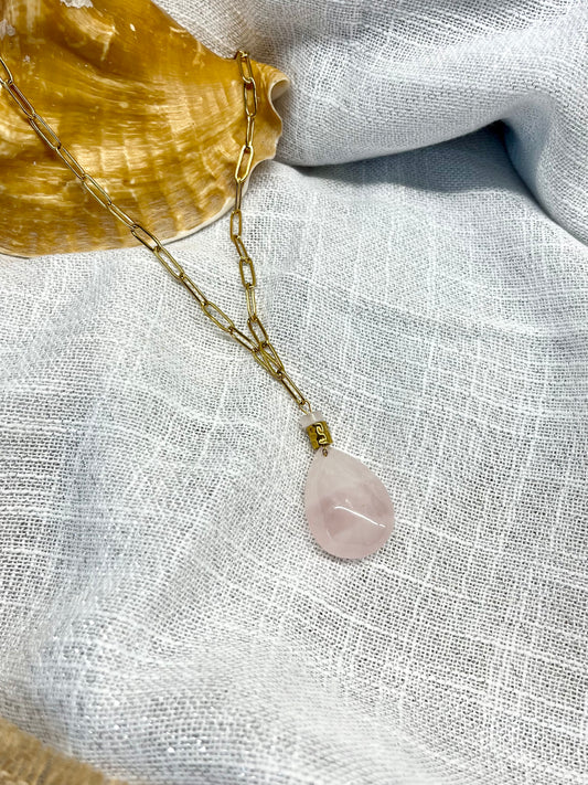Collier MAEVA, avec pierre de Quartz Rose, exposé sur un fond en lin.