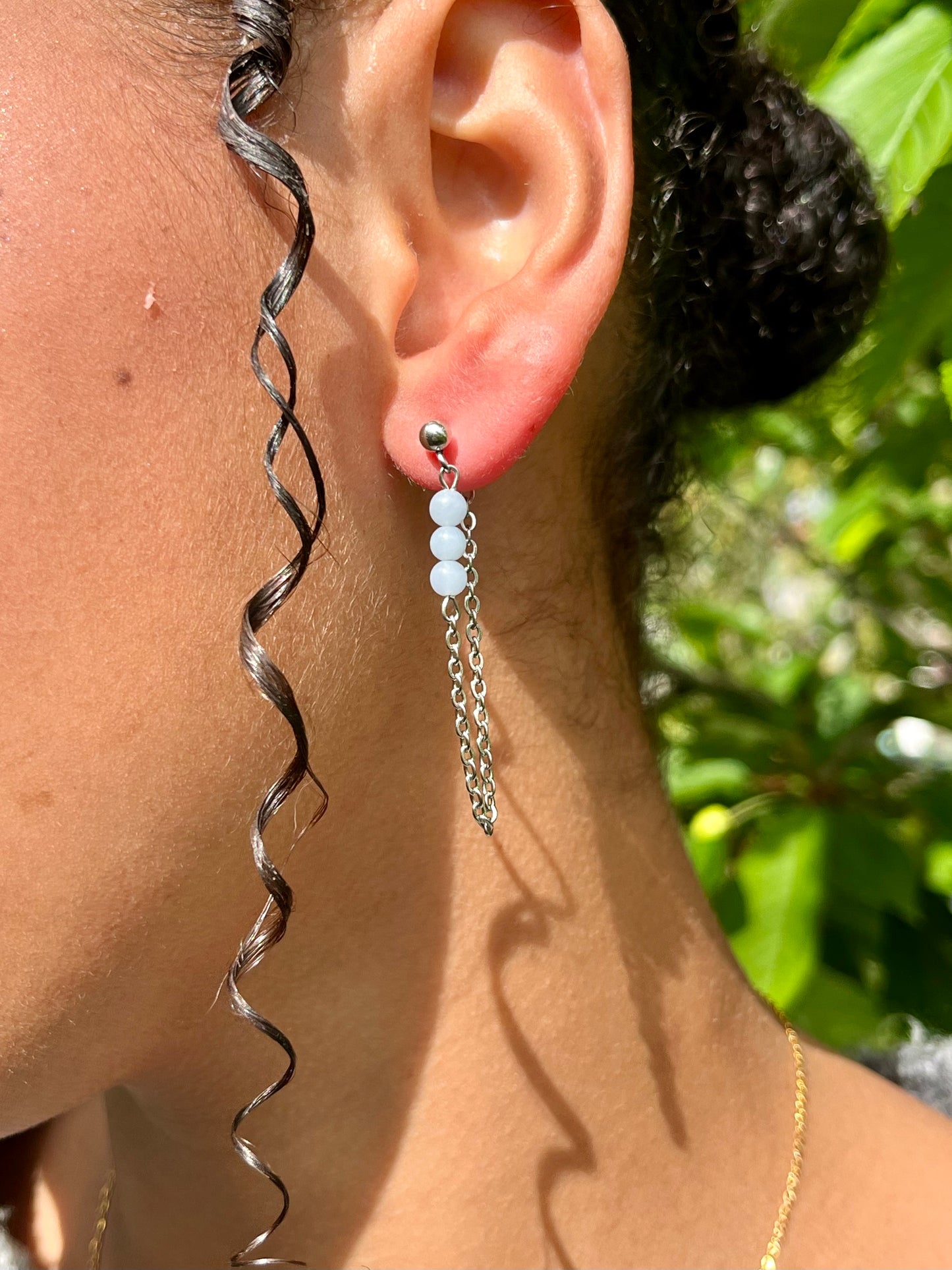 Boucles d'oreille MALIA, de couleur argent avec pierres d'Angélite, portées.