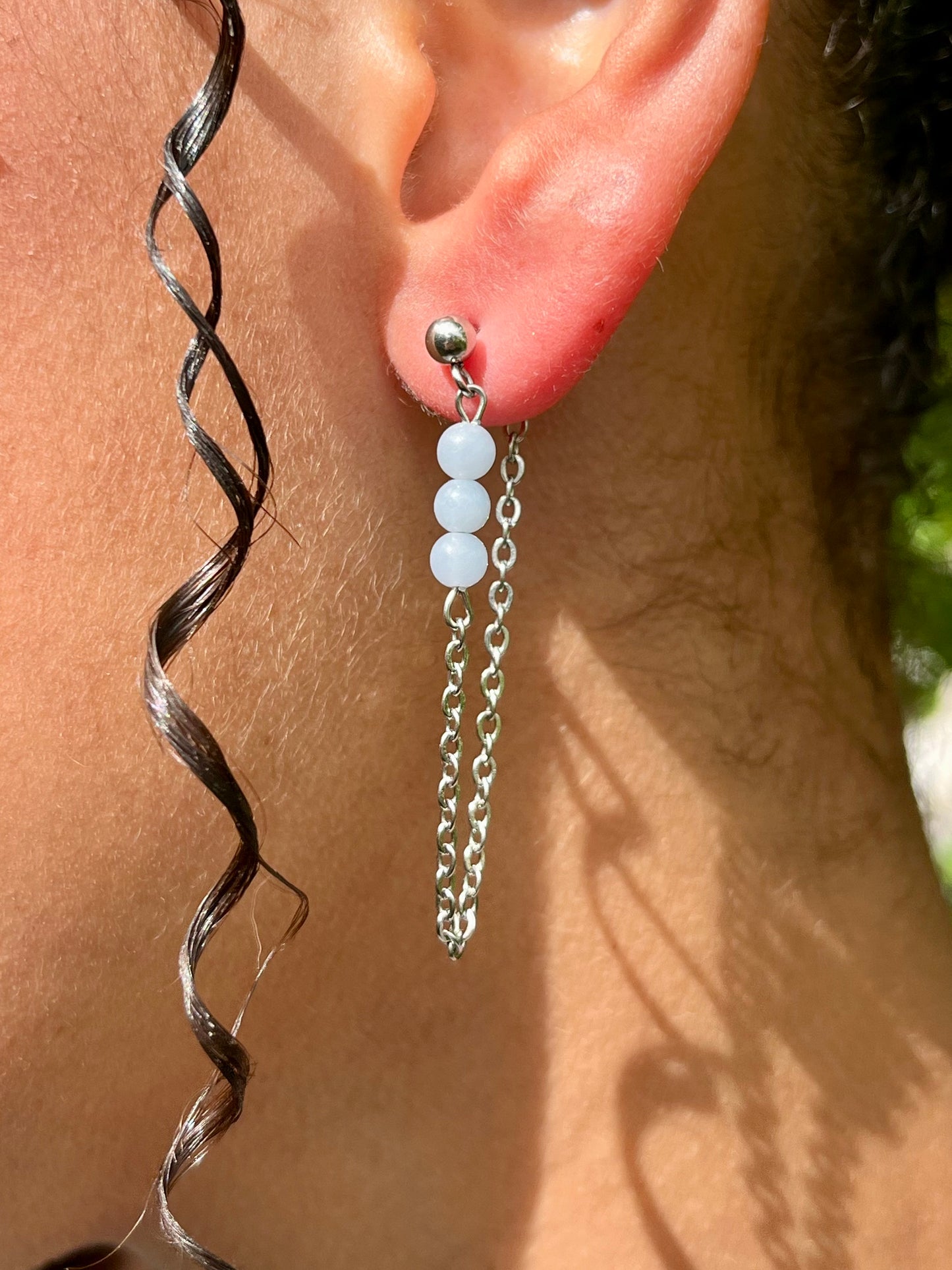 Boucles d'oreille MALIA, de couleur argent avec pierres d'Angélite, portées.