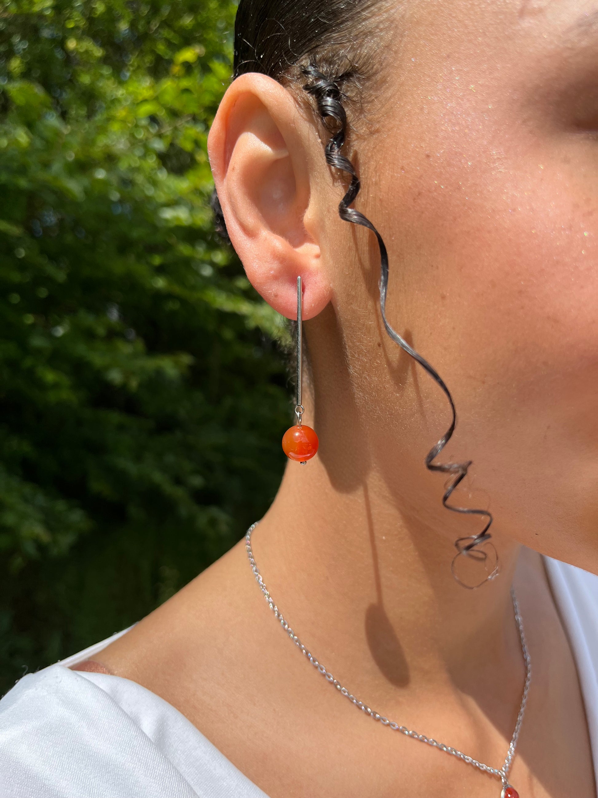 Boucles d'oreille MANON en pierre de Cornaline, portées.