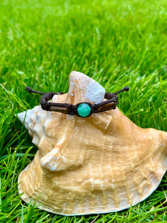 Bracelet NOAH, avec pierres d'Aventurine et d'Oeil de Tigre, exposé sur un coquillage.