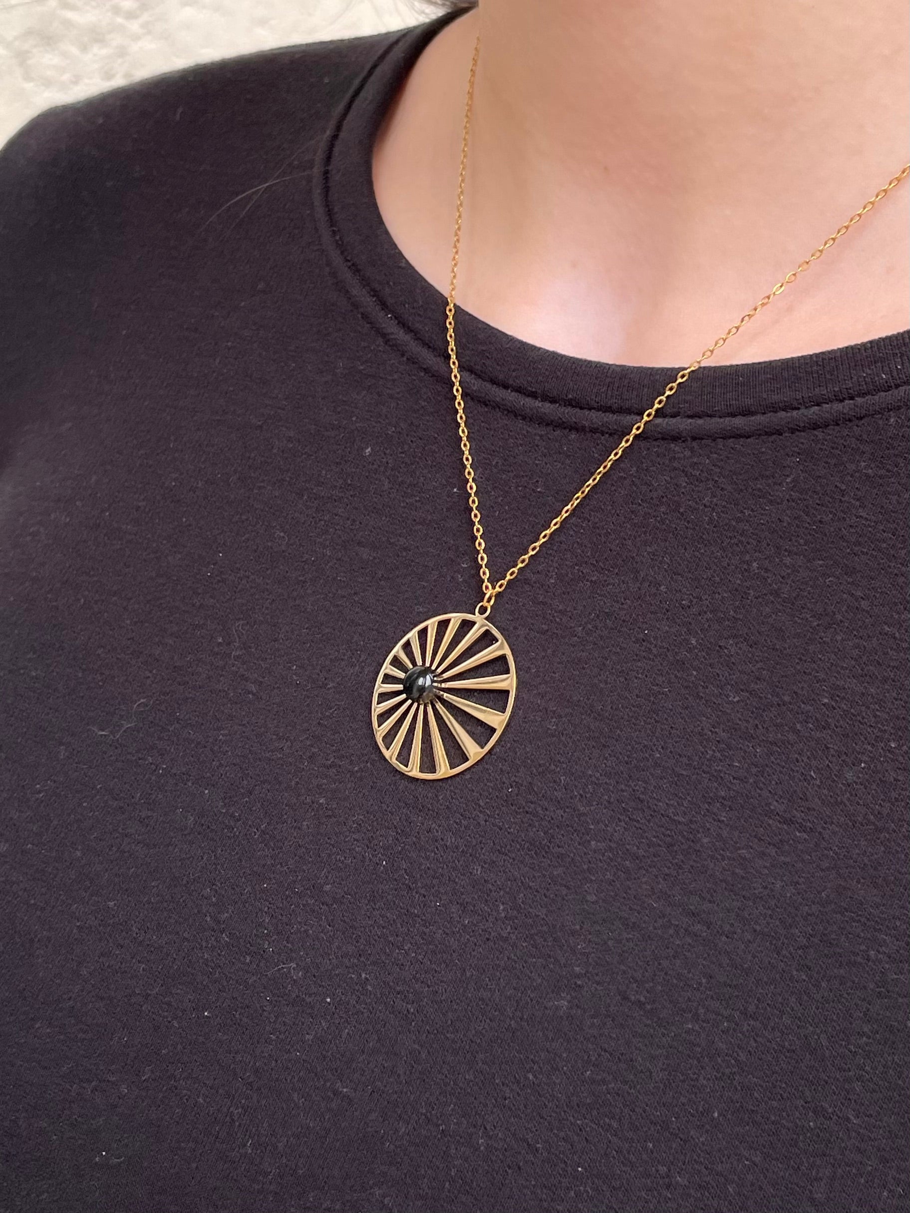Collier SANA, de couleur dorée avec pierre d'Agate, porté.