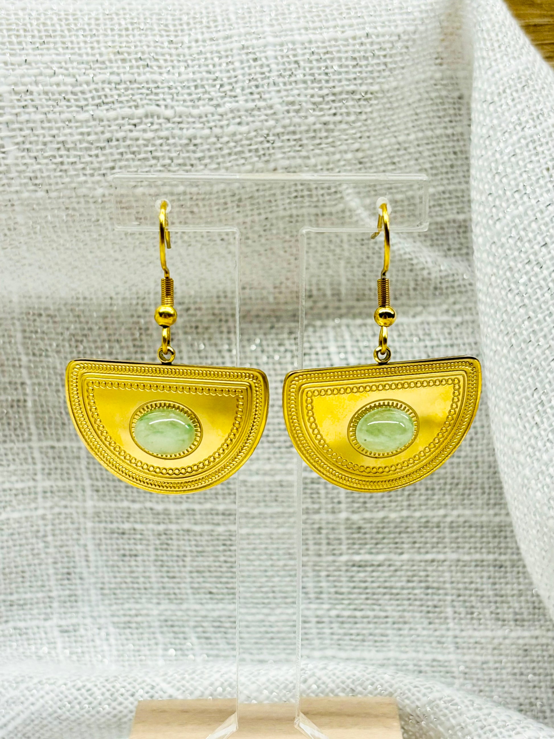 Boucles d'oreille SELENA, en acier inoxydable doré et pierre d'Aventurine, exposées sur un fond en lin.