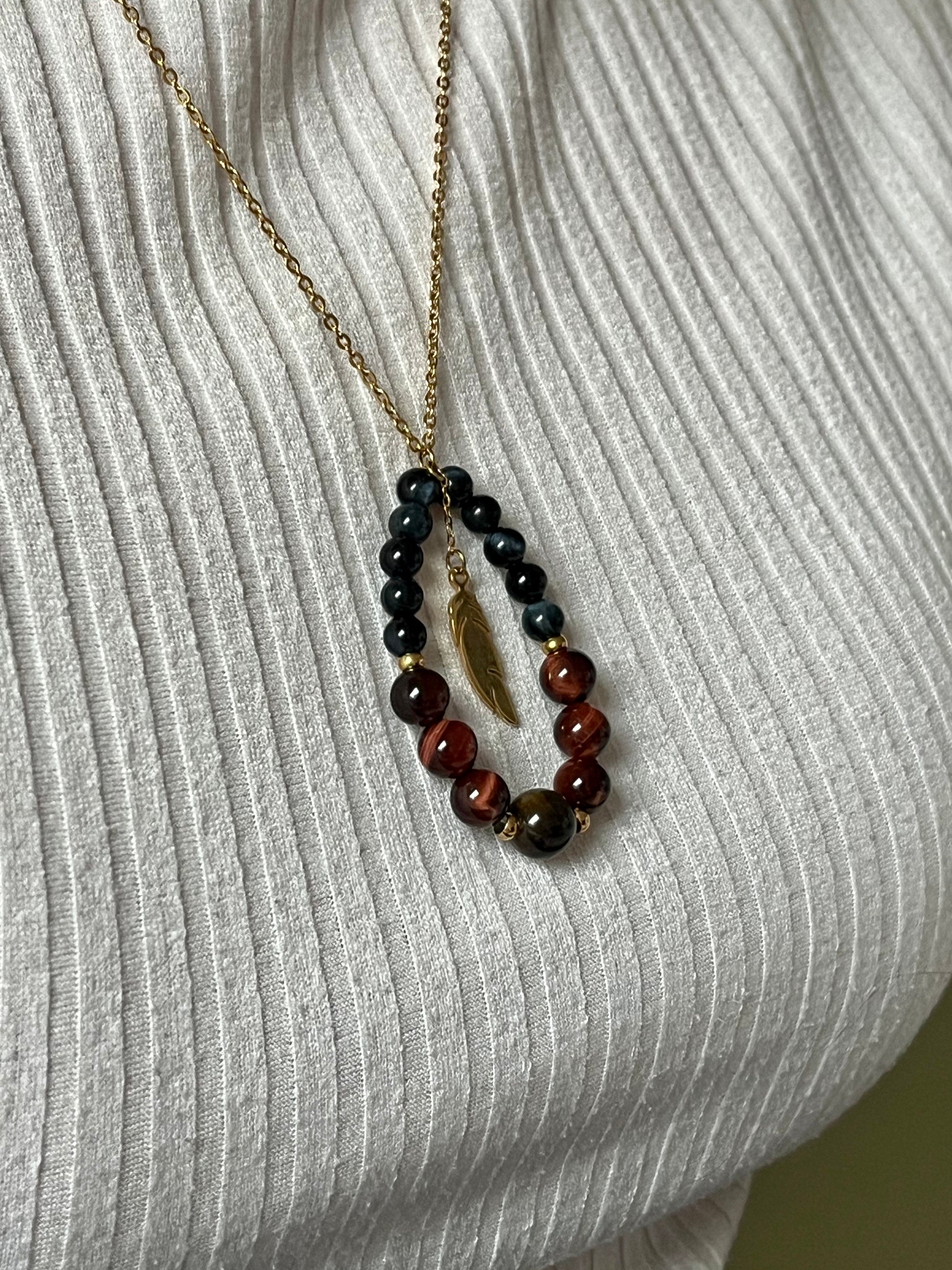 Collier SIMONE, avec pierre d'Oeil de Tigre, de Taureau et de Faucon, porté par une femme sur un haut blanc.