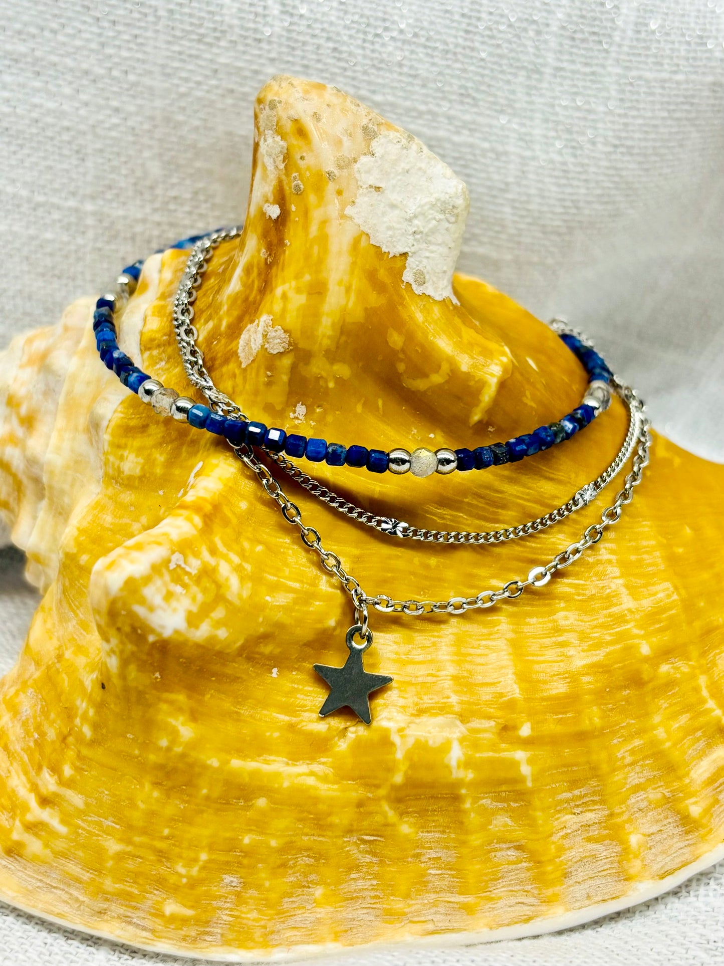 Bracelet STELLA, avec pierre de Lapis-Lazuli et Labradorite, exposé sur un coquillage.